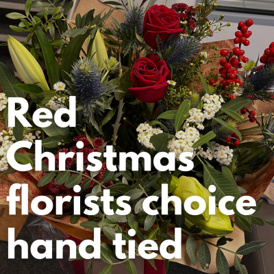 Red Christmas Florist Choice Hand Tied - Our expert, highly qualified florists will design a festive hand-tied filled with the finest quality red seasonal flowers, perfectly wrapped and delivered in water.